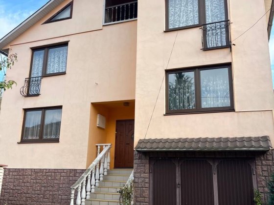 Будинок біля річки Тиса з видом на Карпати. Рахів